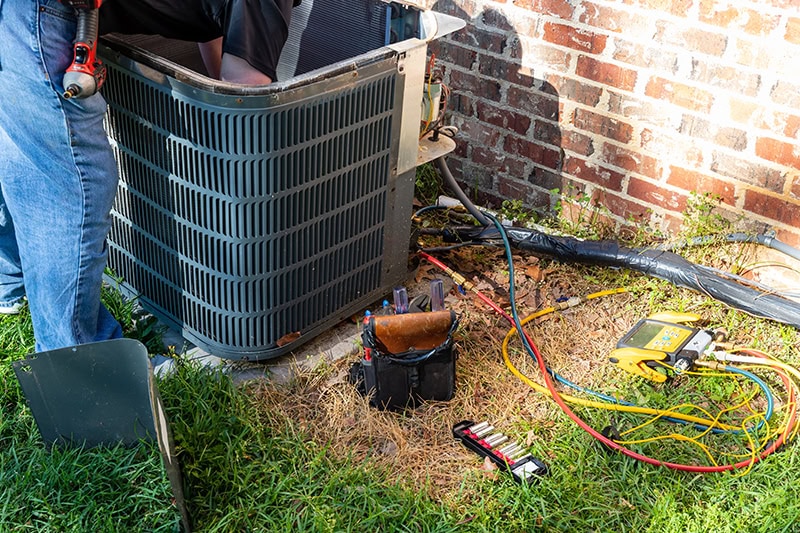 Technician performing AC maintenance on an air conditioner in St. George, UT.